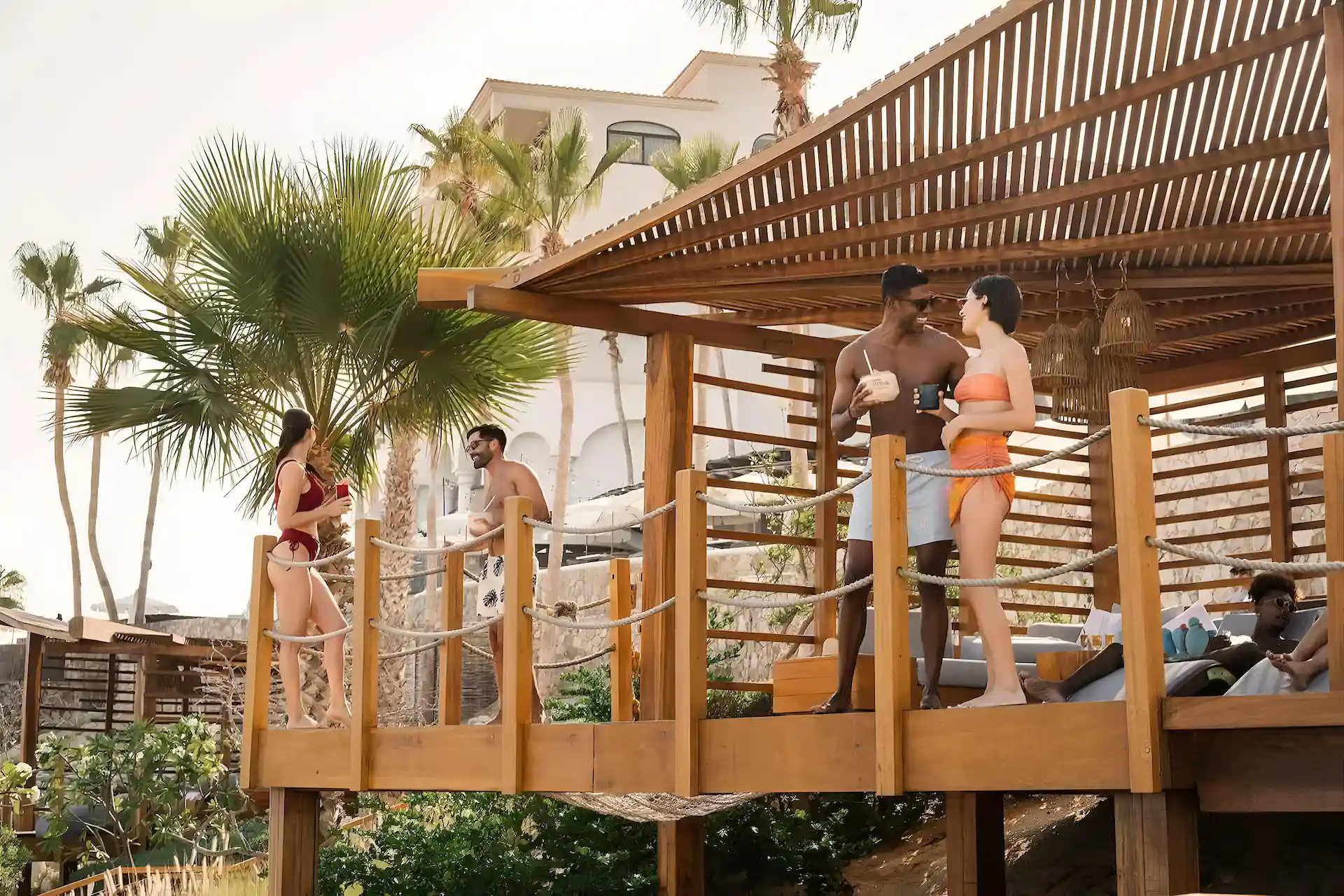 Picture of people standing in the balcony area of a cabin near swimming pool.