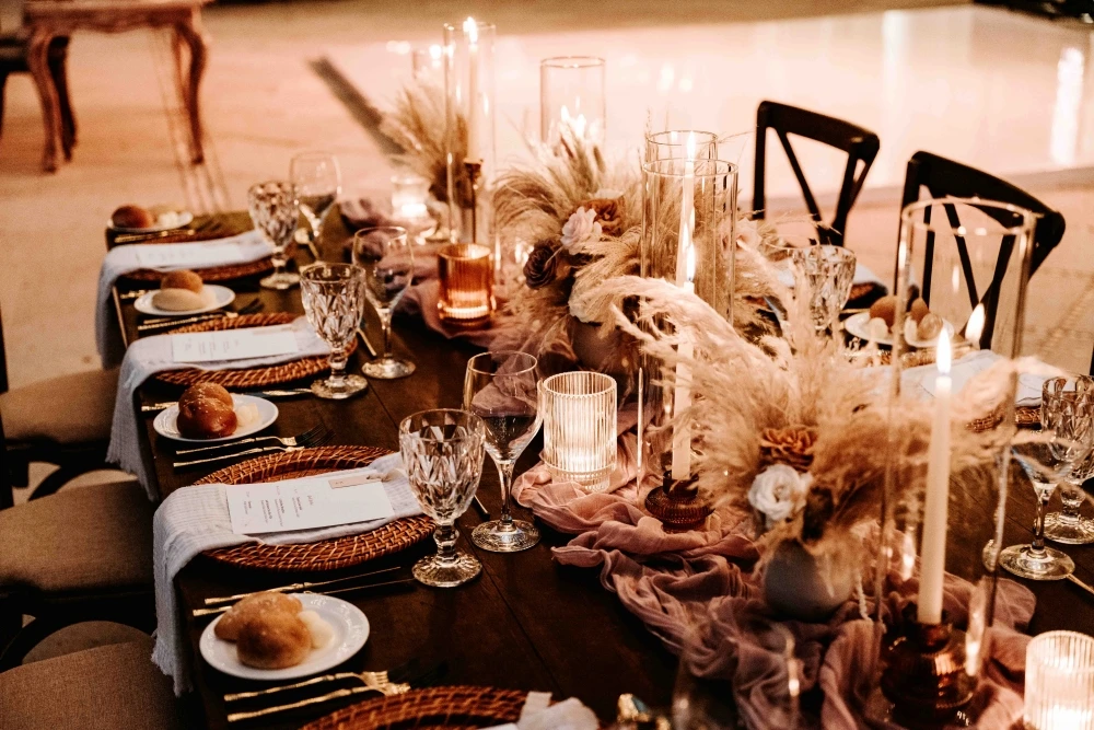 http://Elegant%20dinner%20table%20with%20candles,%20woven%20chargers,%20menus,%20and%20soft%20floral%20décor%20set%20for%20a%20formal%20event.