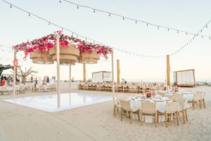 Beachfront event at Hilton Los Cabos with floral decor, string lights, and a sunset-ready dance floor on the sand.