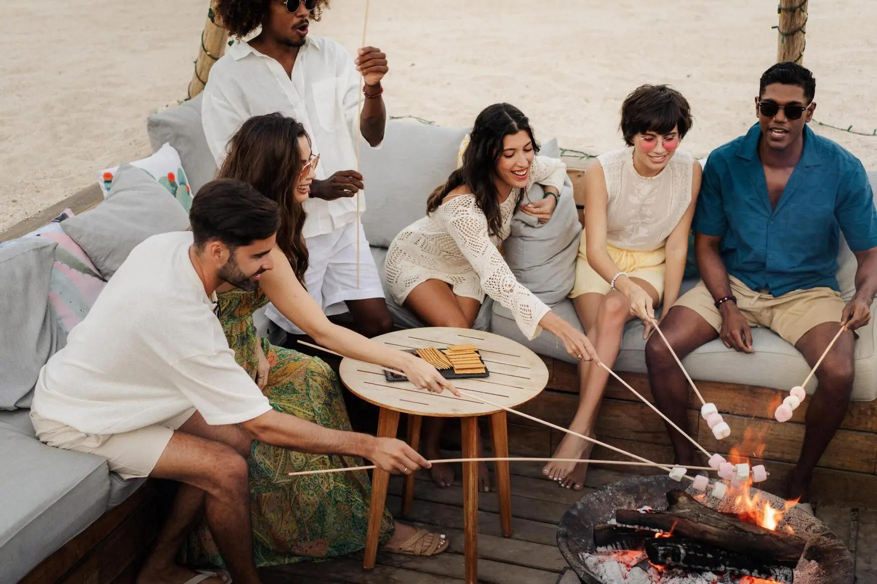 foto de invitados en un café en la playa quemando malvaviscos