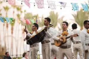 Mariachi band performing in traditional attire under festive papel picado banners at Hilton Los Cabos Beach & Golf Resort