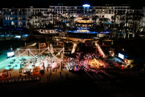 Aerial view of Hilton Los Cabos' oceanfront resort lit up for a New Year's Eve celebration on the beach and pool deck