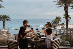 Brindis familiar con vino y cócteles sin alcohol durante una cena frente al mar en el restaurante Vela, Hilton Los Cabos Beach & Golf Resort.