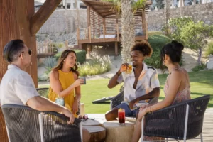 Friends sitting on chairs in garden surrounding area.